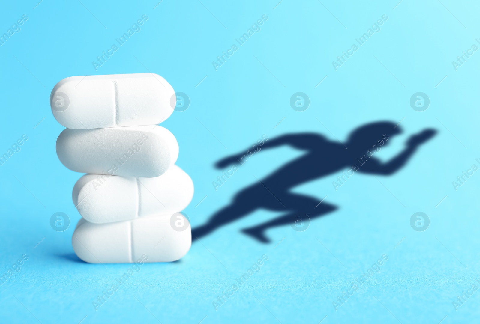 Image of Doping concept. White pills and silhouette of sportsman on turquoise background