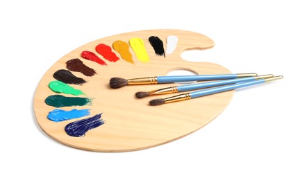 Photo of Palette with paints and brushes on white background. Artist equipment