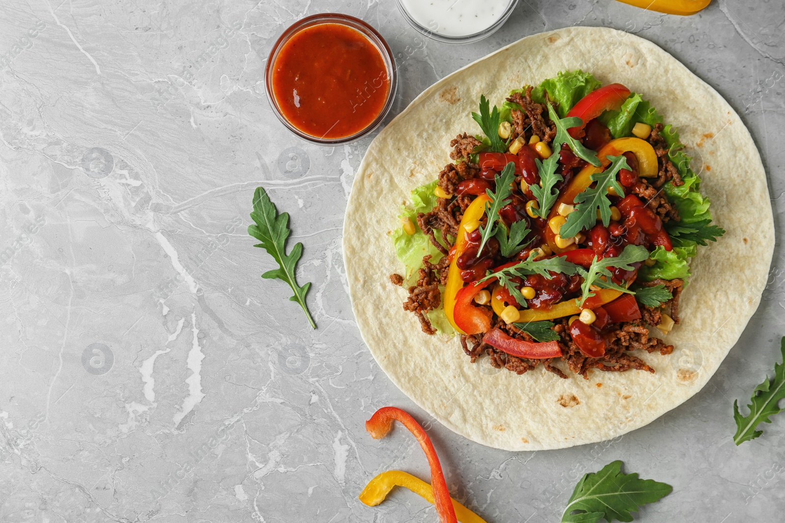 Photo of Delicious tortilla with meat on light table, flat lay. Space for text