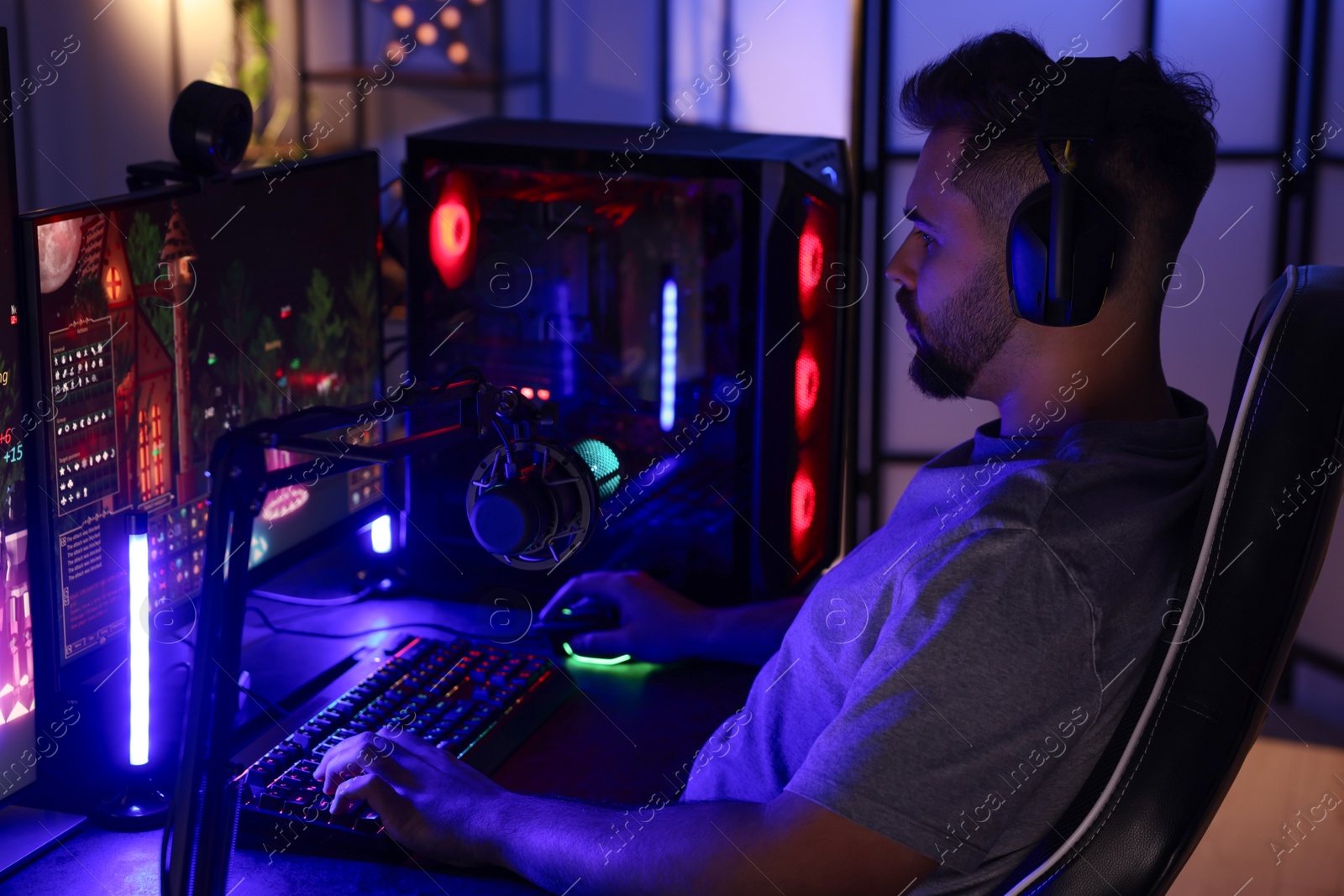 Photo of Man playing video games on computer at table indoors