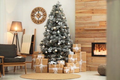 Stylish room interior with beautiful Christmas tree and gift boxes