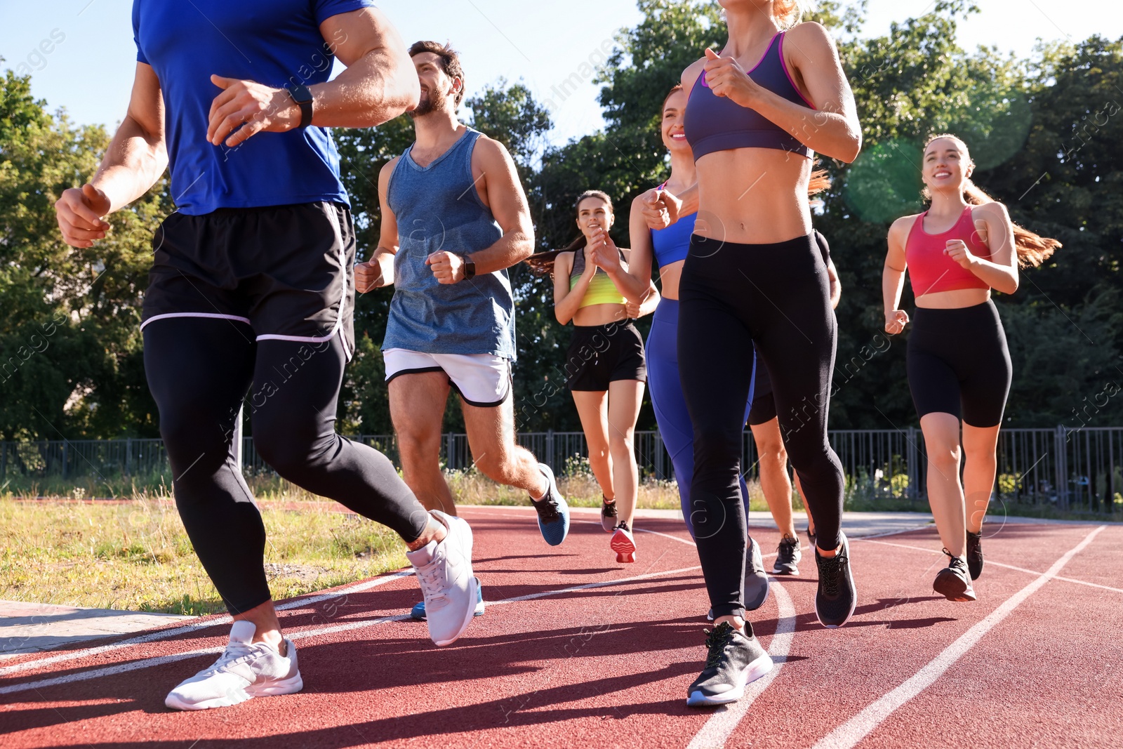 Photo of Group of people running at stadium on sunny day