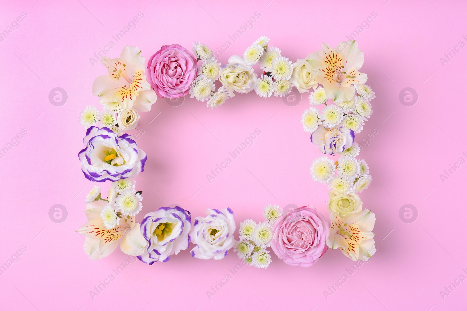 Photo of Frame of fresh flowers on wooden background, top view. Space for text