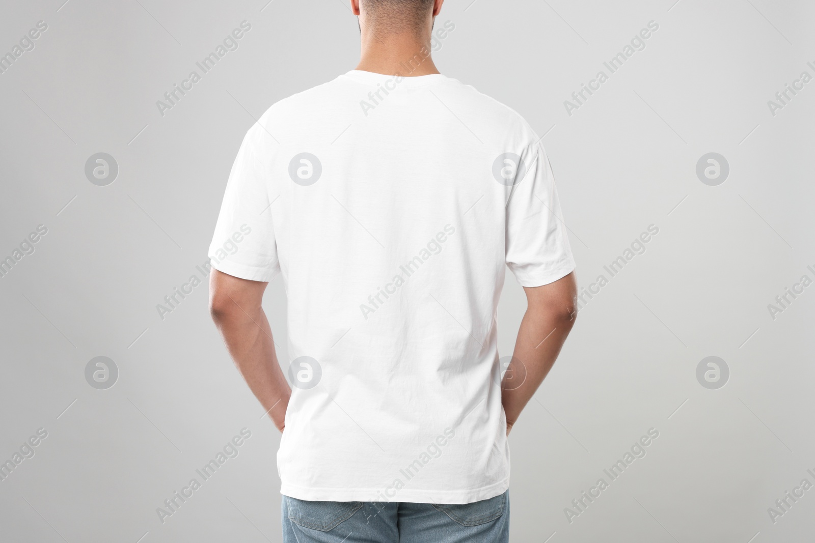 Photo of Man wearing white t-shirt on gray background, closeup
