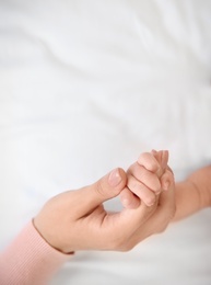 Photo of Mother holding little baby hand