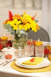 Autumn table setting with floral decor and pumpkins indoors