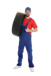 Photo of Full length portrait of professional auto mechanic with tire on white background