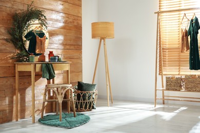 Stylish dressing table and mirror decorated with green eucalyptus in room