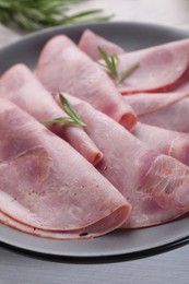 Tasty ham with rosemary on table, closeup