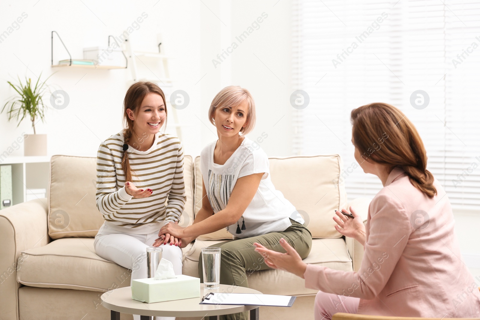 Photo of Psychotherapist working with teenage girl and her mother in office
