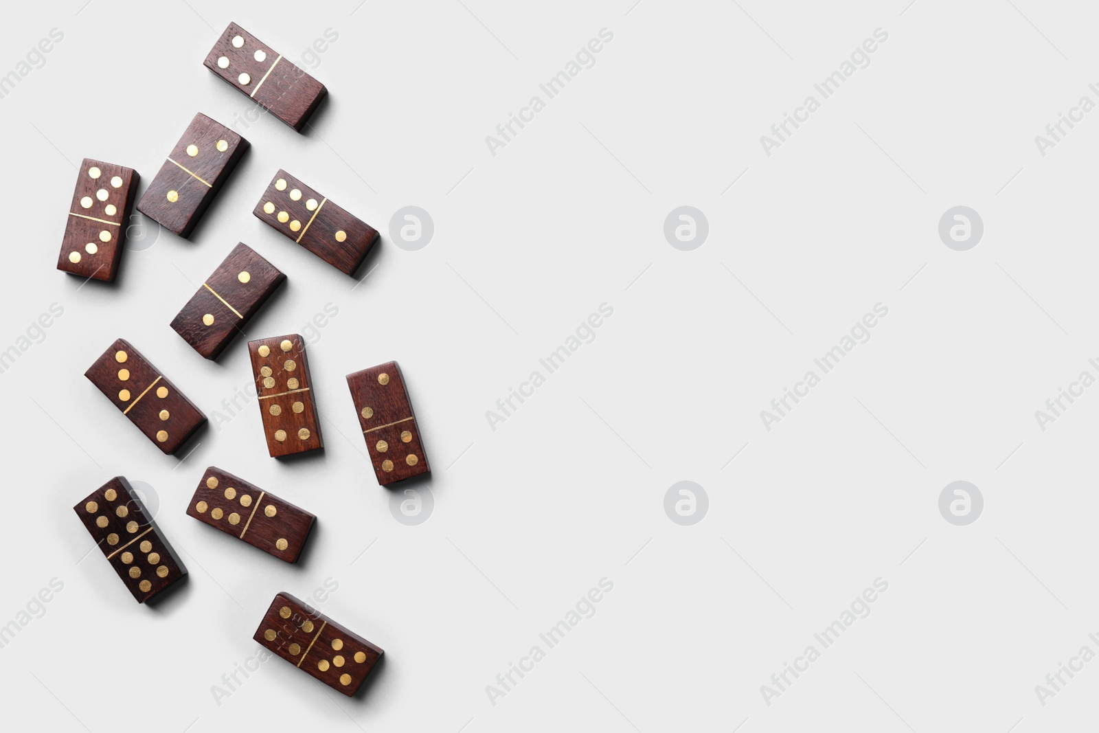 Photo of Wooden domino tiles on white background, flat lay. Space for text