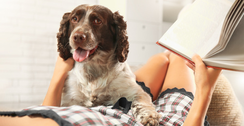 Image of Young woman with her cute Russian Spaniel dog at home, banner design. Lovely pet