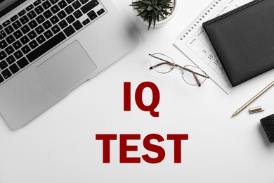 IQ Test. Composition with laptop, glasses and stationery on white background, top view