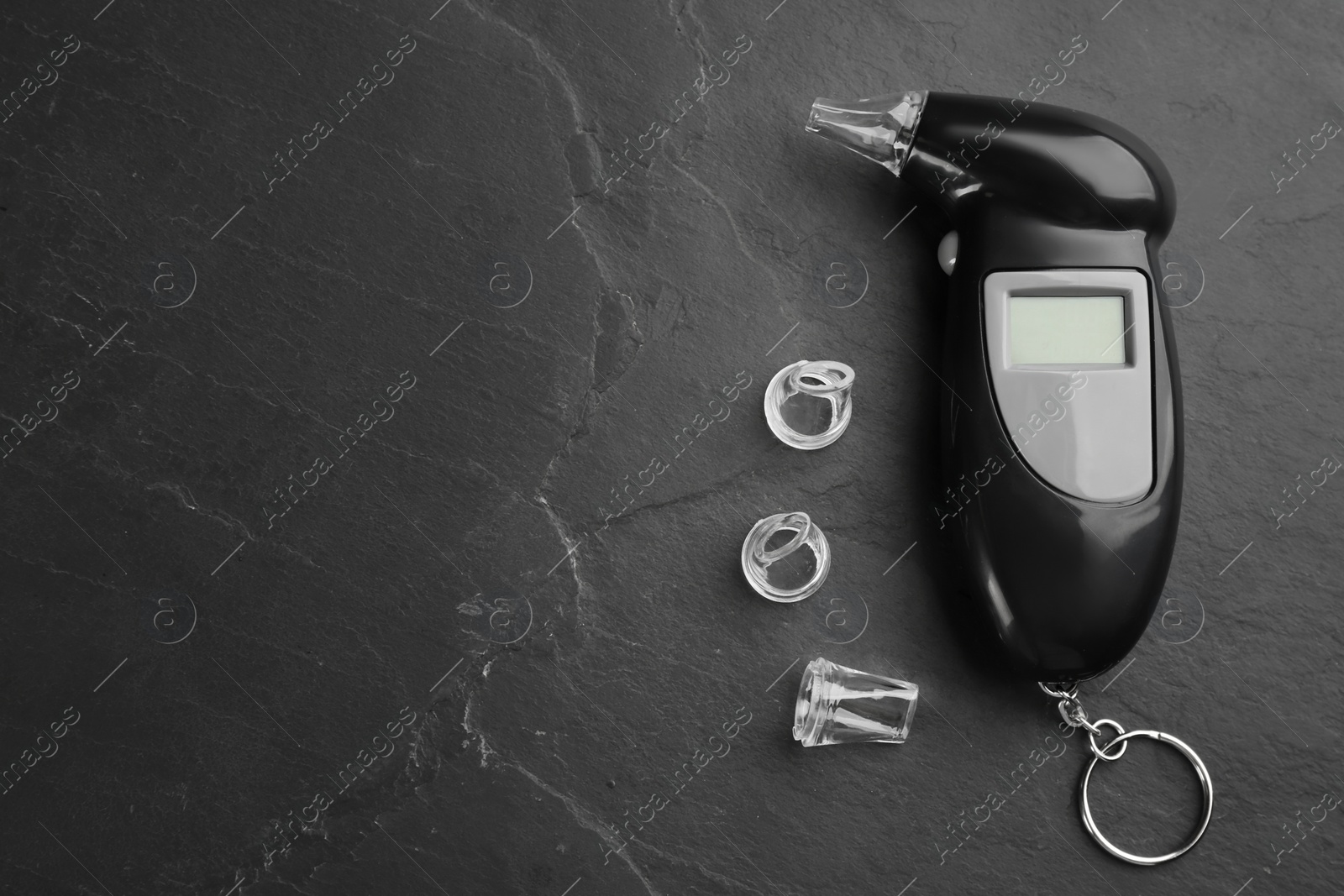 Photo of Modern breathalyzer and mouthpieces on black background, flat lay. Space for text