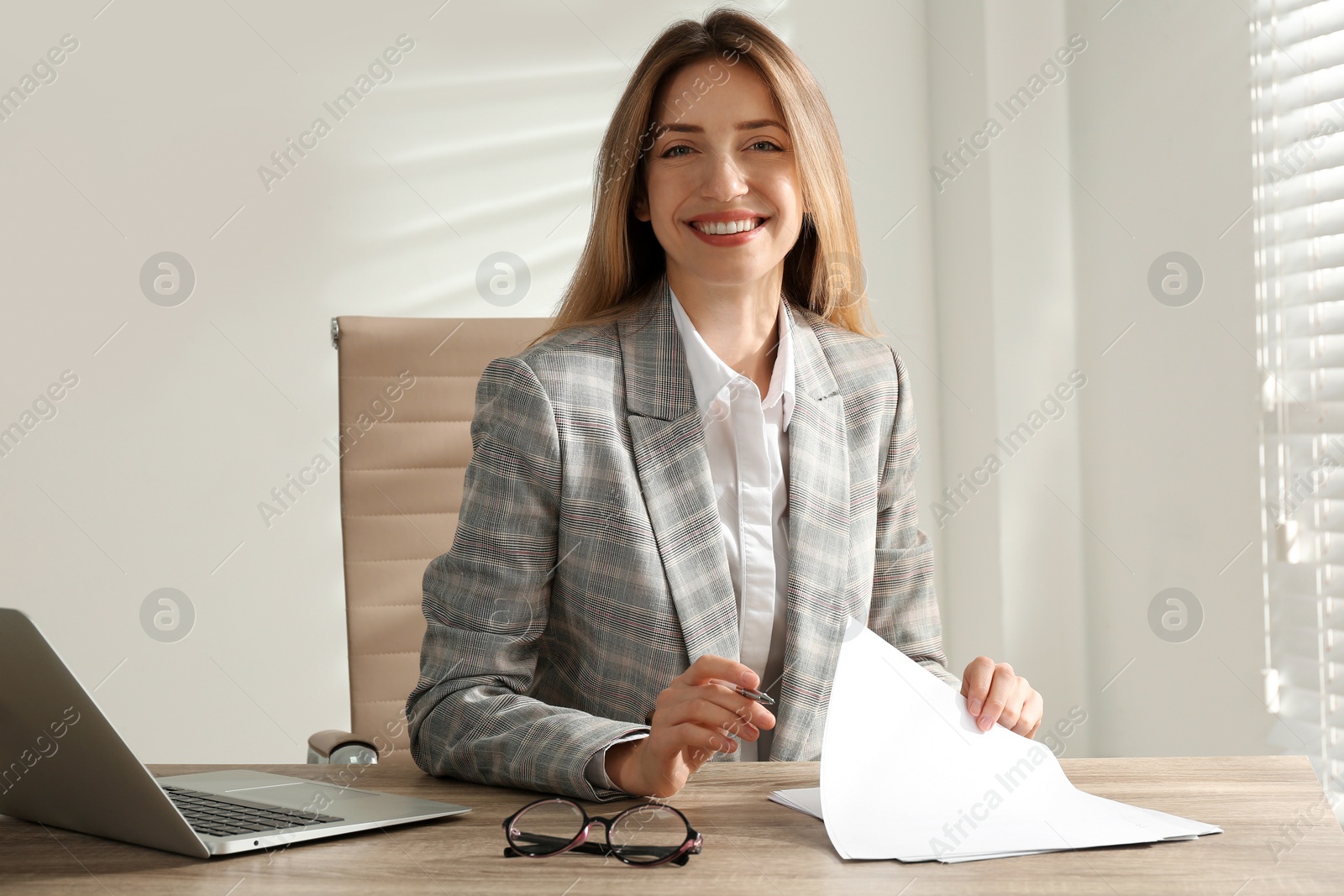 Photo of Portrait of beautiful young businesswoman with laptop at table in office