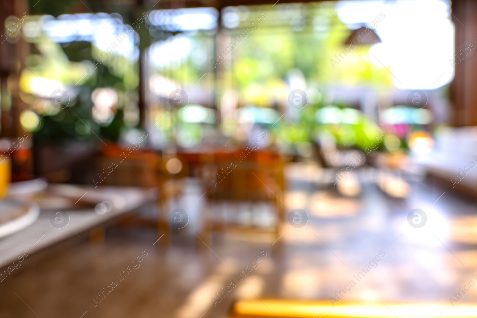 Photo of Blurred view of comfortable cafeteria with furniture