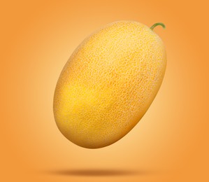 Image of Whole ripe melon falling on orange background