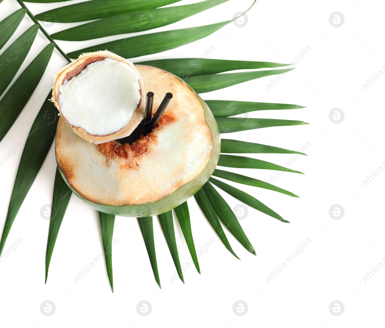 Photo of Fresh green coconut with drinking straws and palm leaf on white background