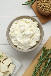 Photo of Delicious tofu cheese, soy beans and rosemary on white wooden table, flat lay