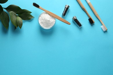 Photo of Bowl of tooth powder, brushes, dental flosses and plant on turquoise background, flat lay. Space for text