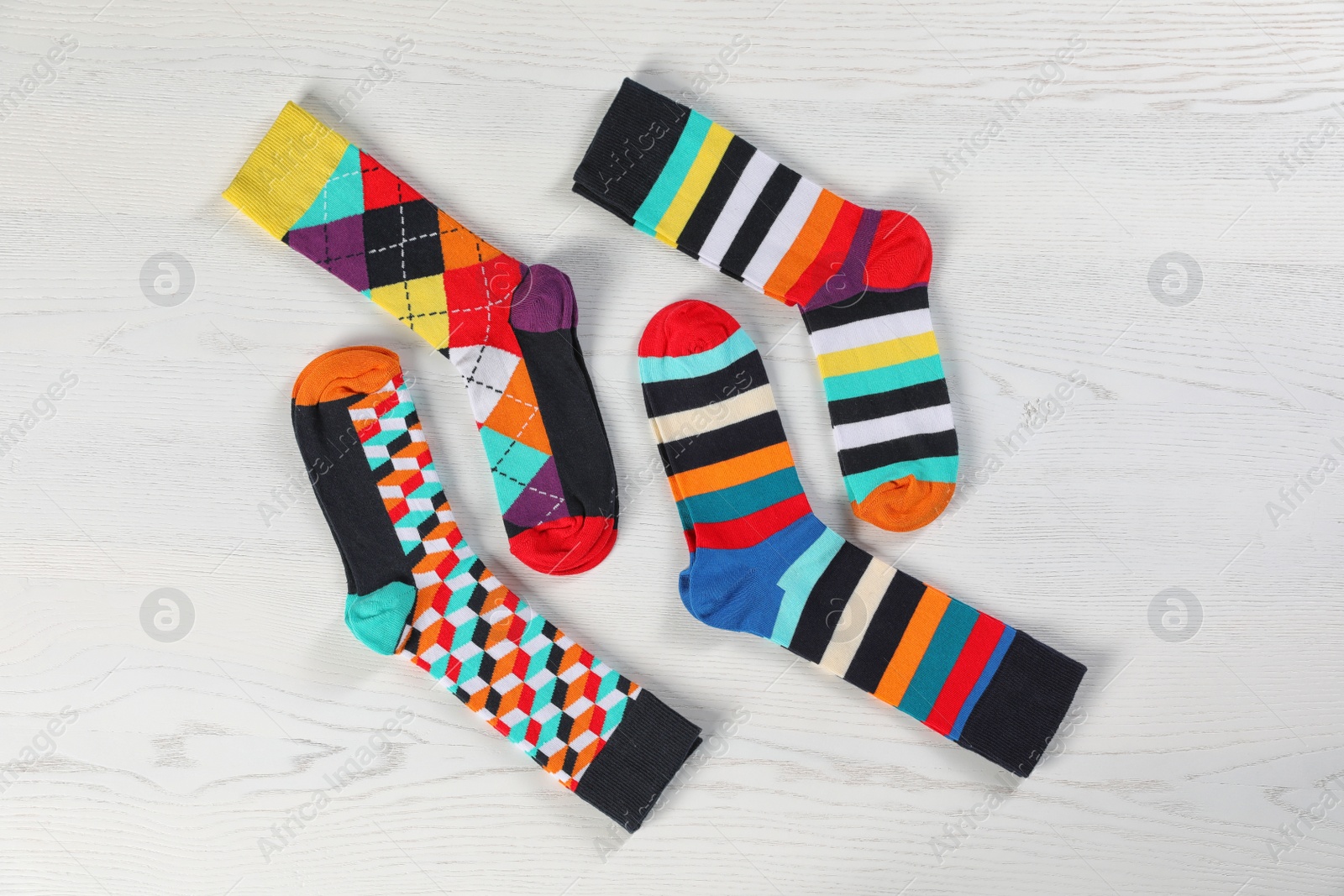 Photo of Flat lay composition with different socks  on light wooden background