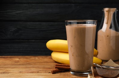 Photo of Tasty banana smoothie and ingredients on wooden table. Space for text