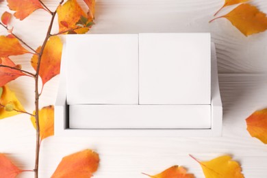 Photo of Thanksgiving day, holiday celebrated every fourth Thursday in November. Block calendar and branch with orange leaves on white wooden table, flat lay