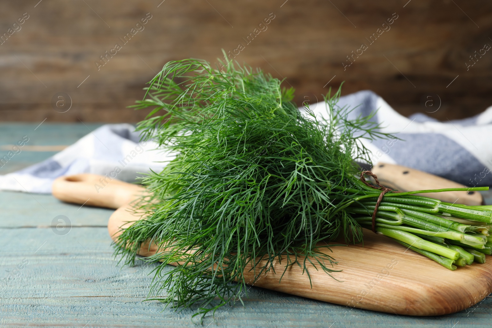 Photo of Bunch of fresh dill on light blue wooden table