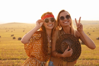 Photo of Portrait of beautiful happy hippie women in field
