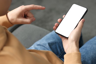 Photo of Man using smartphone with blank screen indoors, closeup. Mockup for design