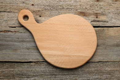 Photo of New cutting board on old wooden table, top view