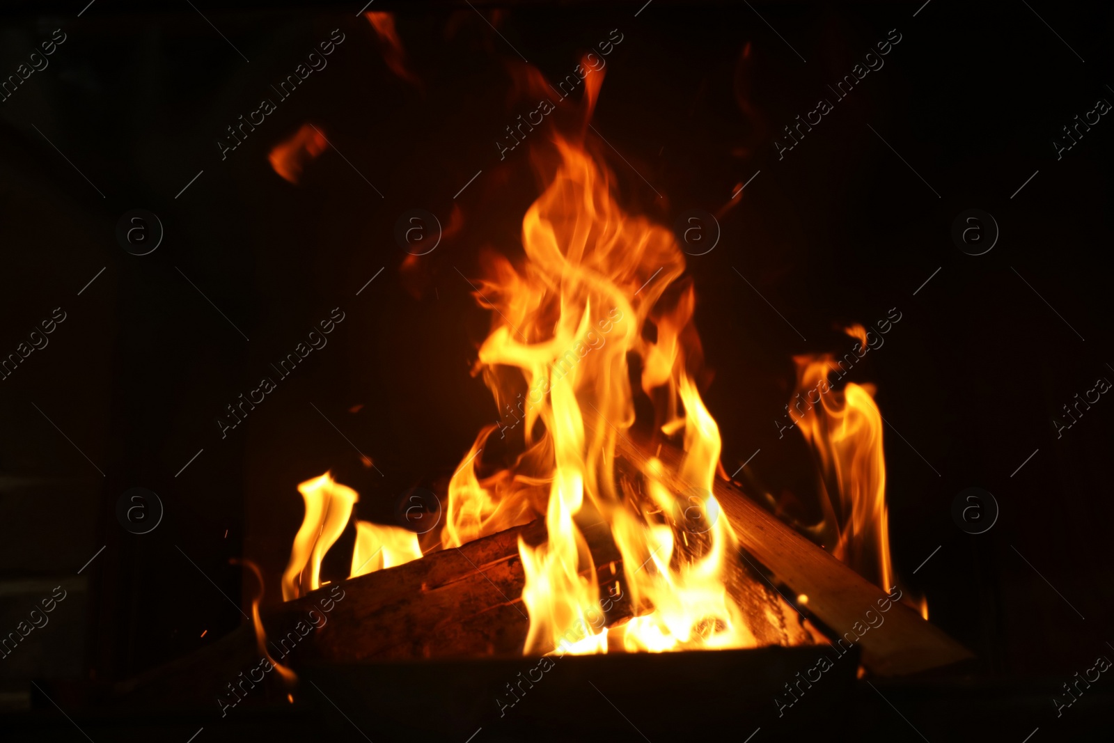 Photo of Fireplace with burning wood, closeup view. Winter vacation