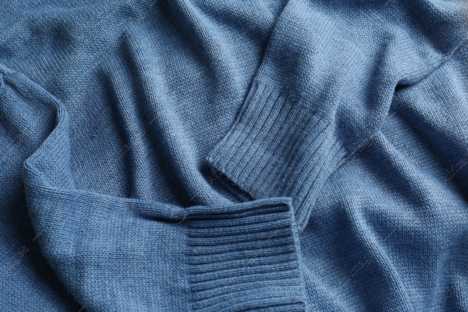 Photo of Soft stylish knitted sweater as background, closeup