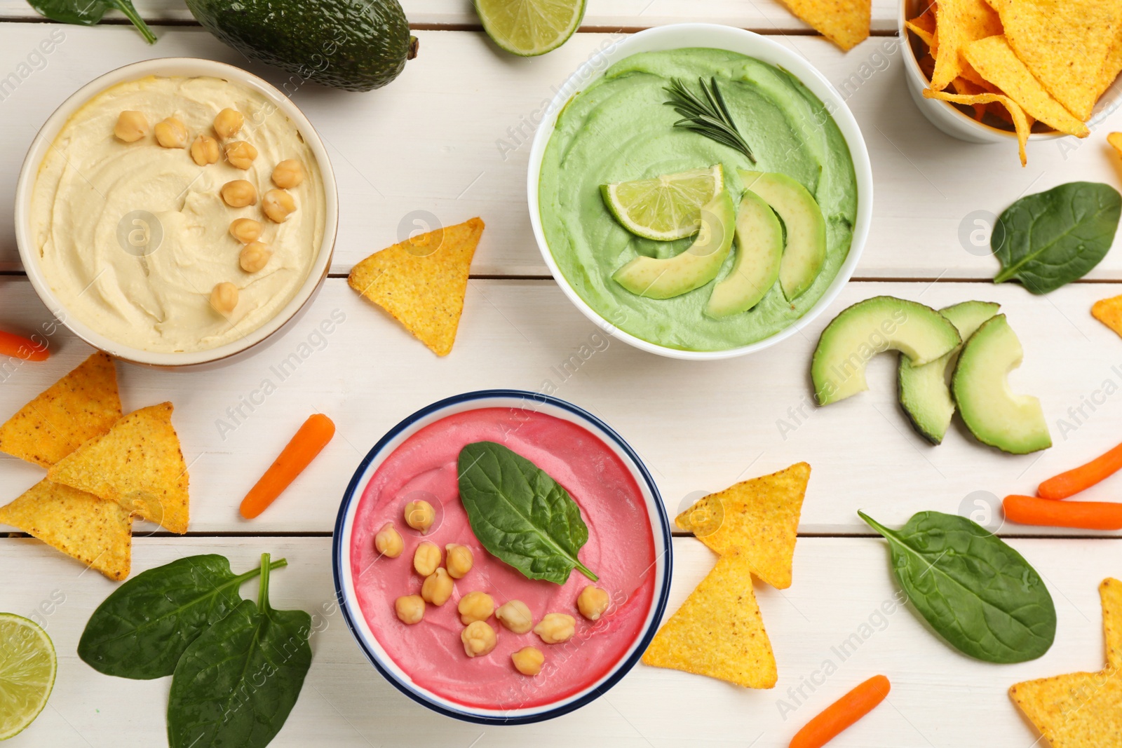 Photo of Flat lay composition with delicious hummuses on white wooden table