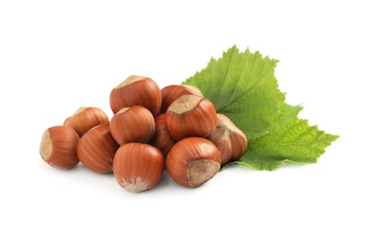 Tasty organic hazelnuts and leaves on white background