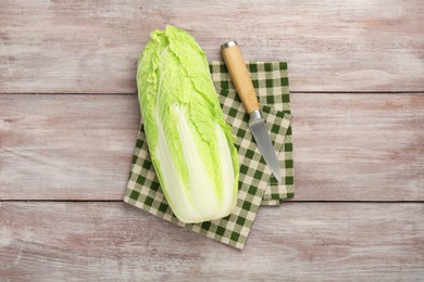 Fresh ripe Chinese cabbage and knife on wooden table, top view