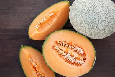 Tasty orange ripe melons on wooden table, flat lay