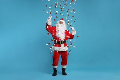 Image of Santa Claus under falling confetti on light blue background