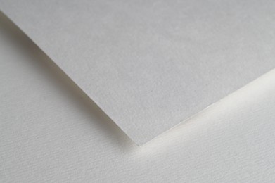 Blank watercolor paper sheet on white background, closeup