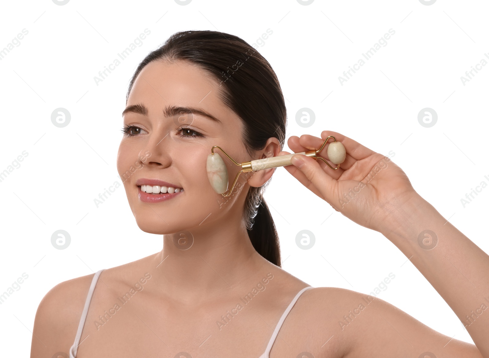 Photo of Young woman massaging her face with jade roller on white background