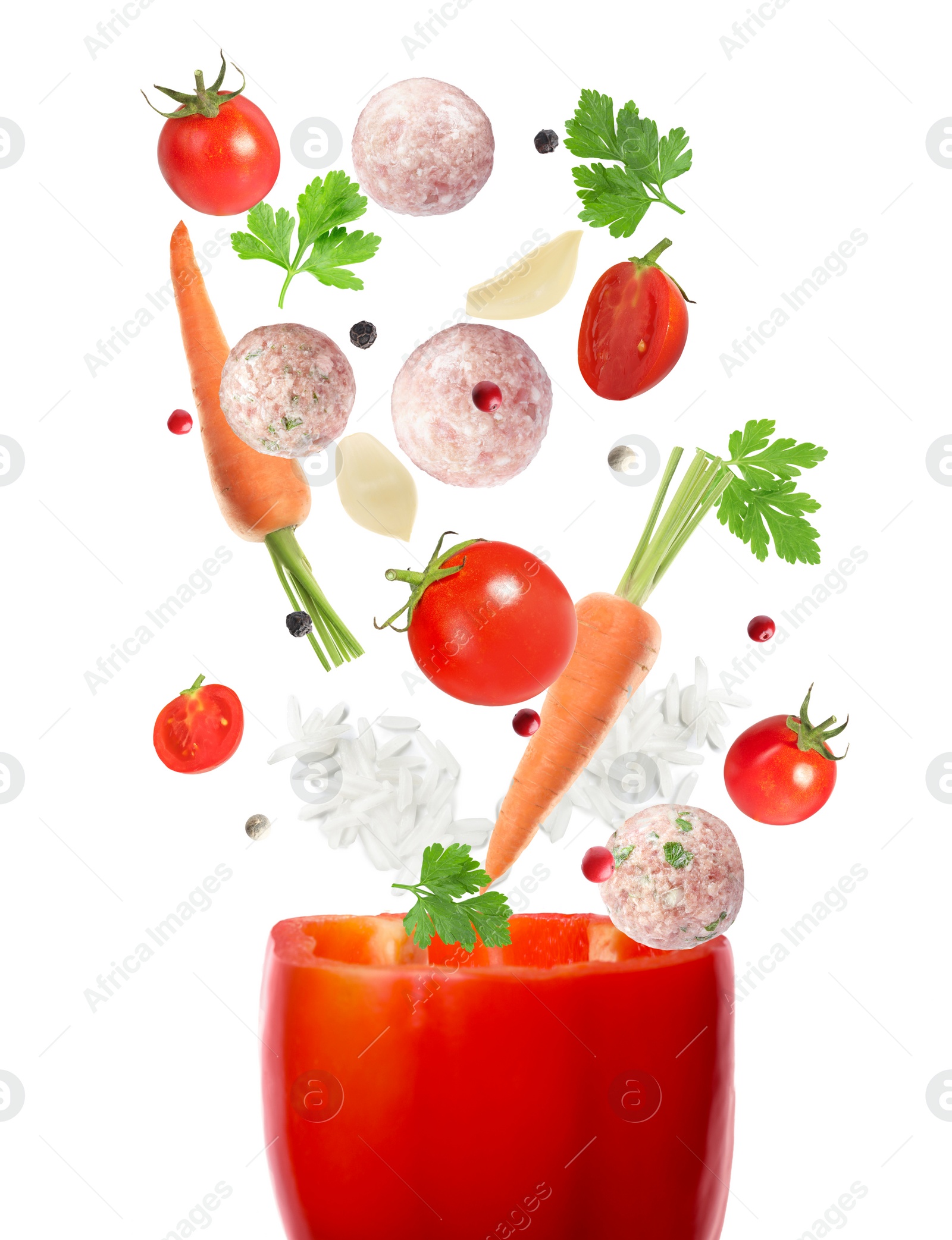 Image of Stuffed pepper recipe. Fresh ingredients falling into bell pepper on white background