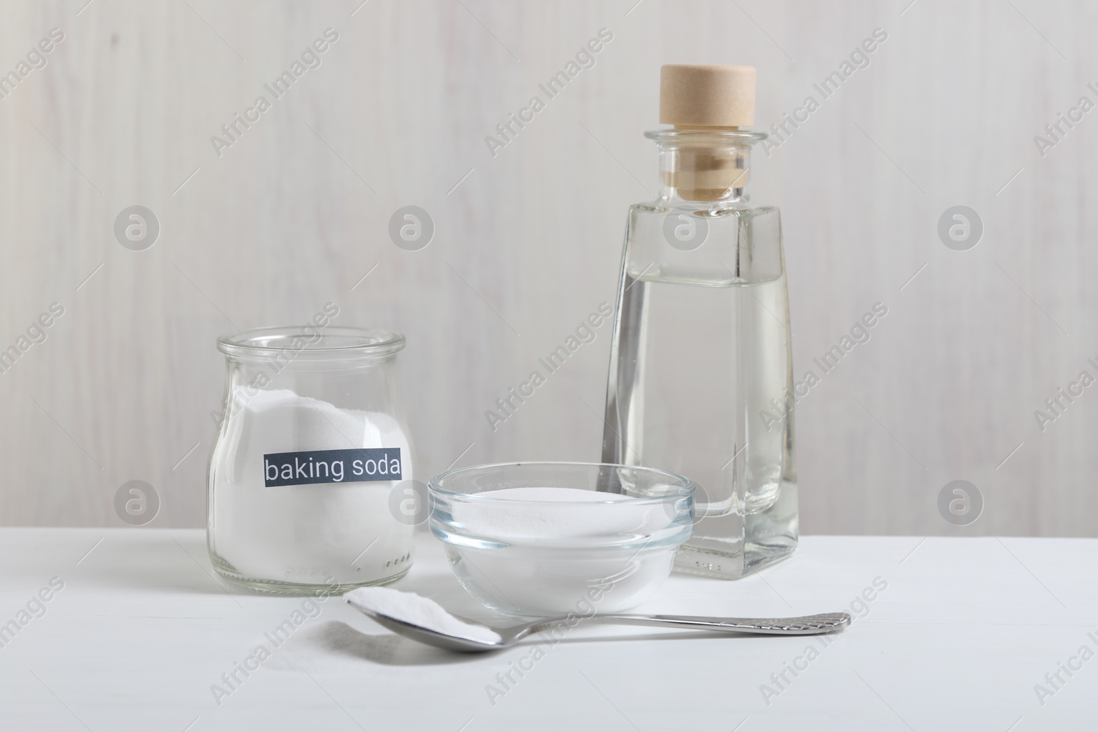 Photo of Baking soda and vinegar on white wooden table