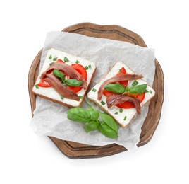 Photo of Delicious sandwiches with cream cheese, anchovies, tomatoes and basil on white background, top view