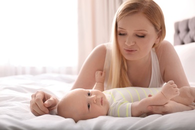 Mother with her little baby on bed at home