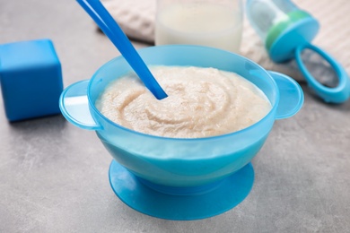 Healthy baby food in bowl on grey table