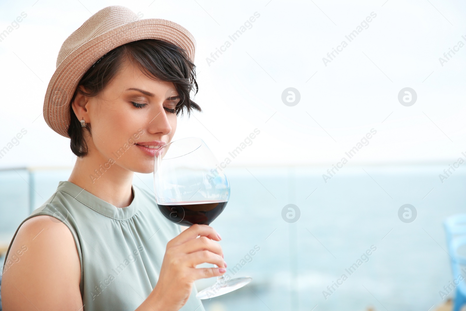 Photo of Young woman with glass of red wine outdoors
