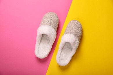 Pair of beautiful soft slippers on colorful background, top view