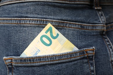 Photo of Euro banknote in pocket of jeans, closeup. Spending money