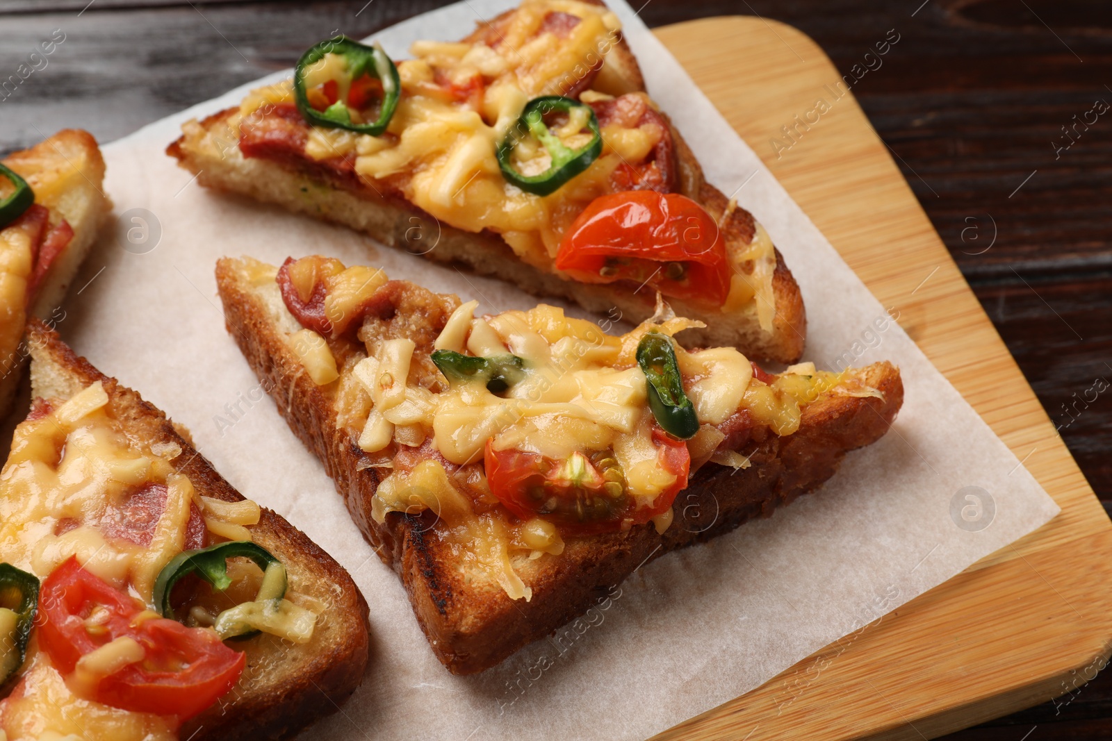 Photo of Tasty pizza toasts served on wooden table, closeup