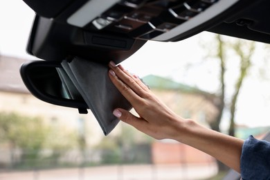 Woman wiping her modern car with rag, closeup